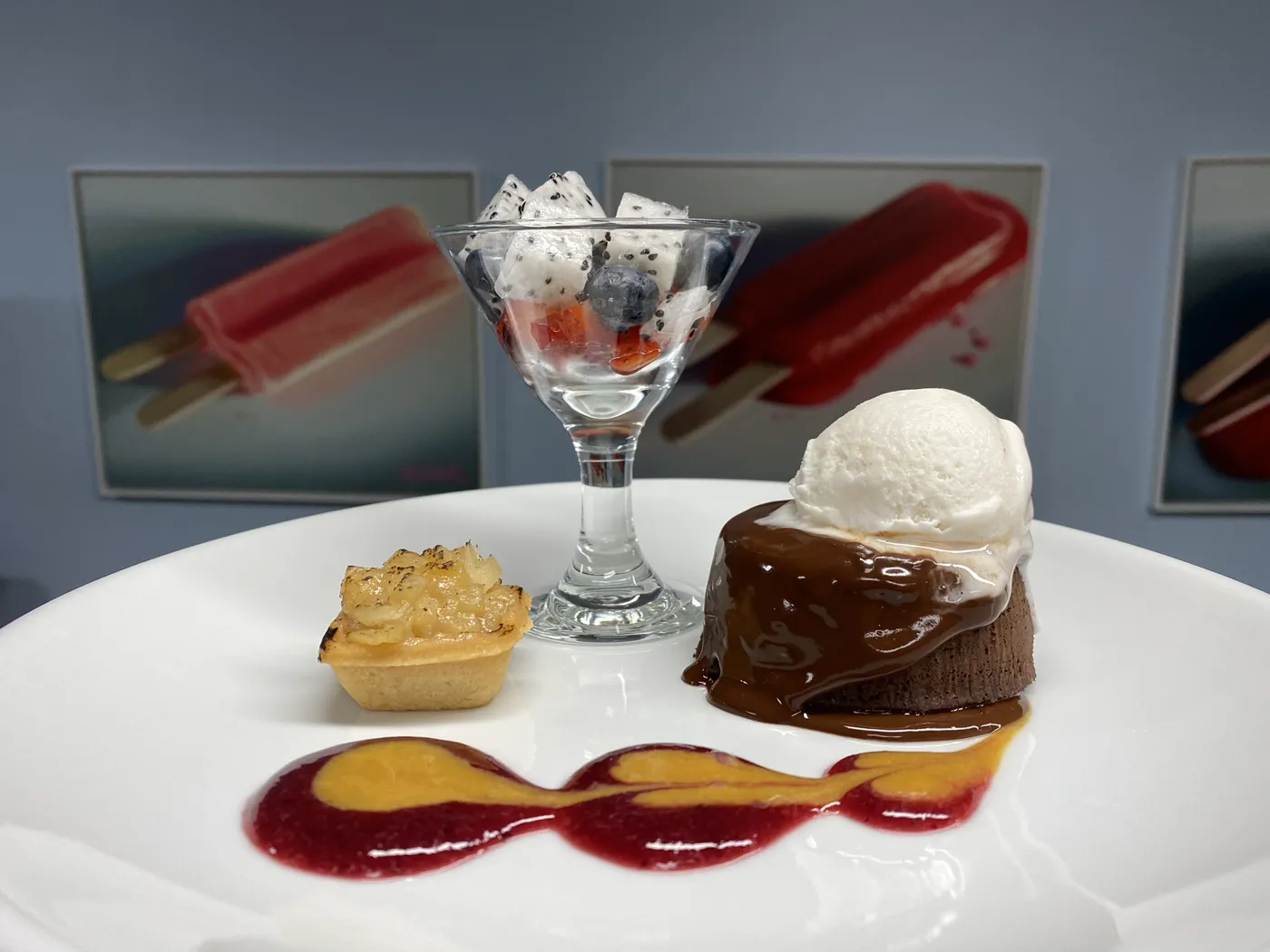 Plated chocolate lava cake with ice cream, fruit cup and tart