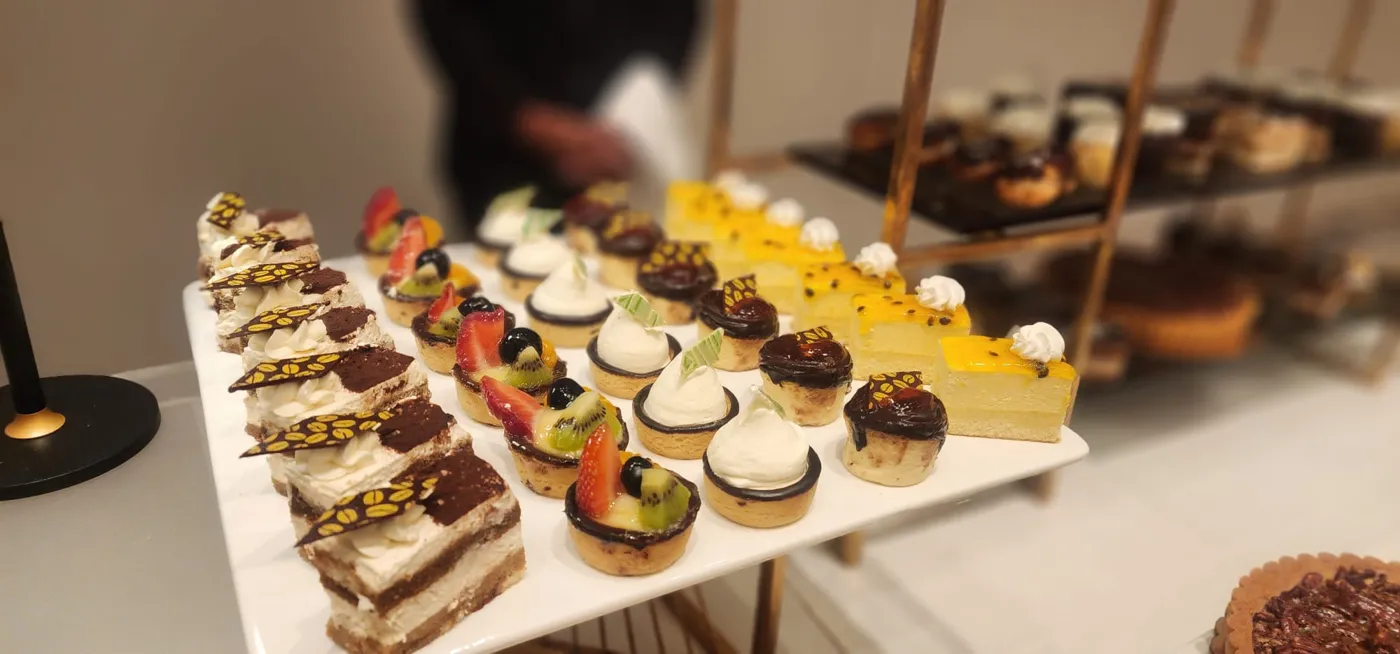 Tray of mini fruit tarts, tiramisu and passion fruit cheesecake
